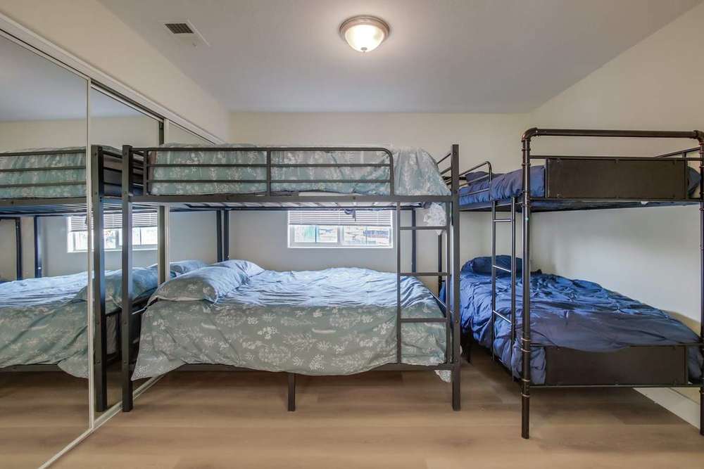 The second bunk room: a full-over-full bunk and a twin-over-twin bunk against a mirrored wardrobe wall